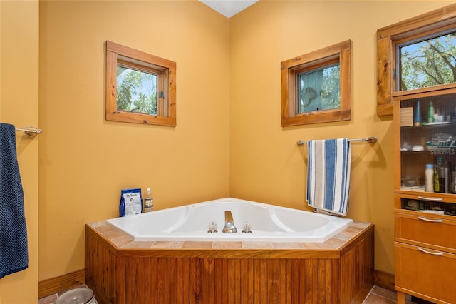 bathroom with a washtub and tile patterned flooring