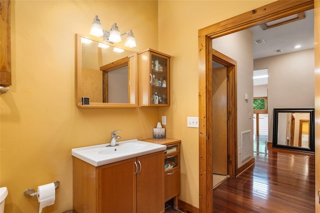 bathroom with hardwood / wood-style floors, toilet, and vanity