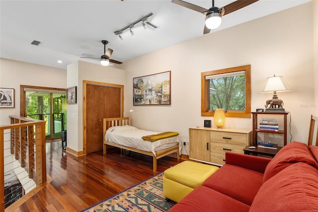 bedroom featuring ceiling fan, rail lighting, and dark hardwood / wood-style floors