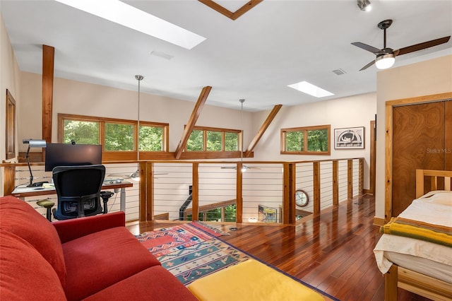 living room with a skylight, a wealth of natural light, ceiling fan, and hardwood / wood-style floors