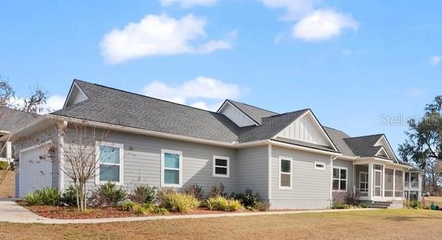 view of side of property featuring a garage and a yard