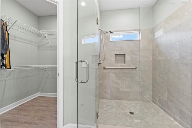 bathroom with a shower with door and wood-type flooring