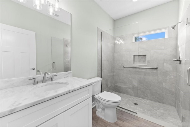 bathroom featuring vanity, toilet, a shower with shower door, and hardwood / wood-style floors