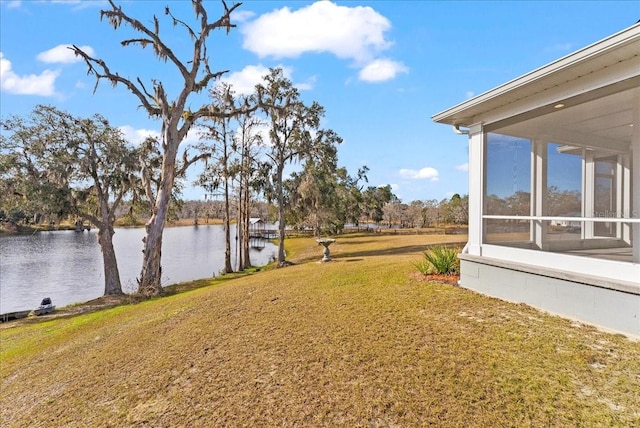 view of yard featuring a water view and a sunroom