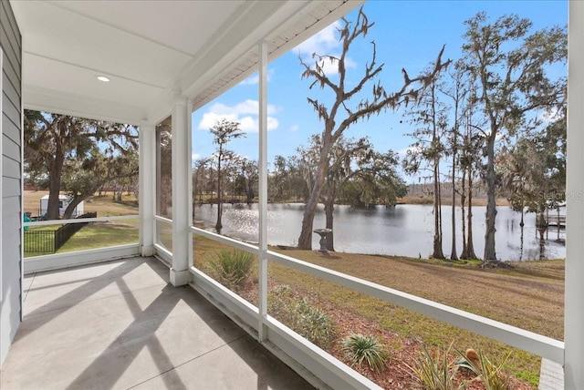 unfurnished sunroom featuring a water view