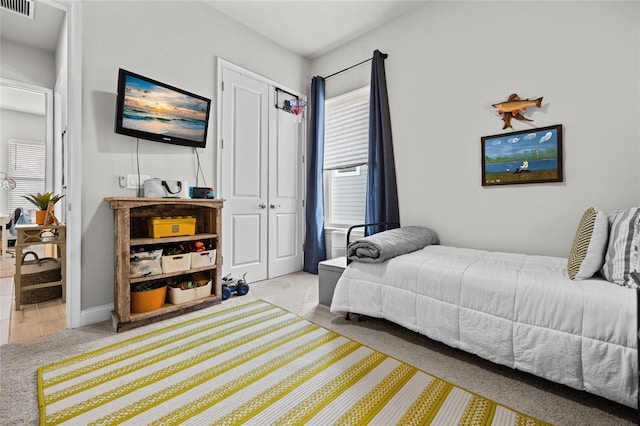 bedroom featuring baseboards, visible vents, a closet, and light carpet