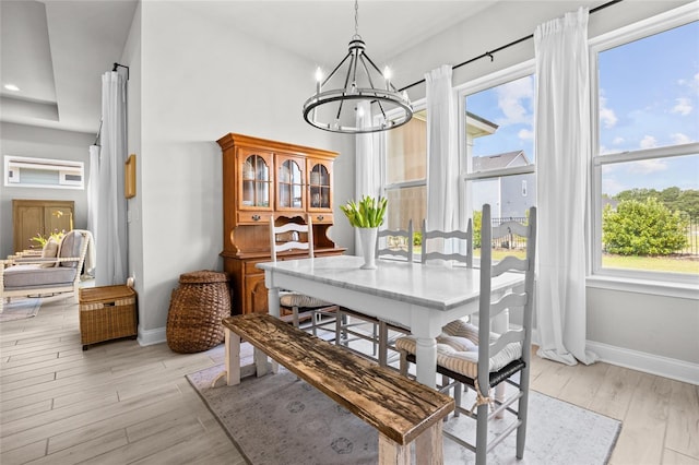 dining room with light wood finished floors, plenty of natural light, and a notable chandelier