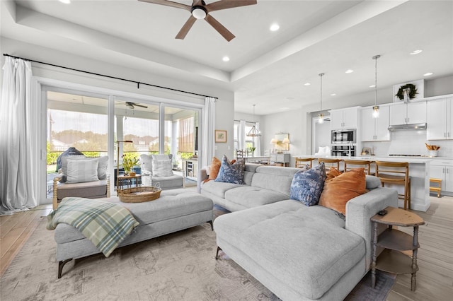 living room with light hardwood / wood-style floors and ceiling fan