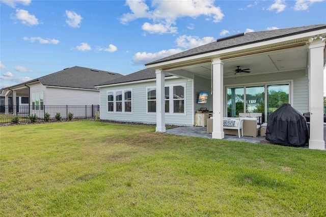 rear view of house with ceiling fan, outdoor lounge area, a lawn, and a patio area