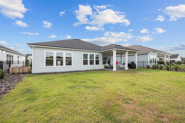 rear view of property featuring a fenced backyard, a patio area, and a yard