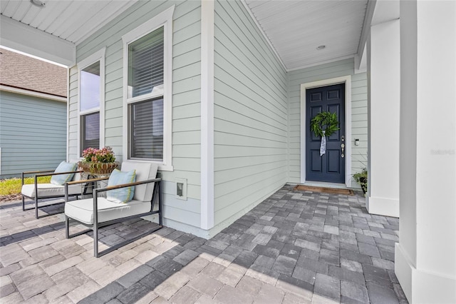 view of exterior entry featuring covered porch