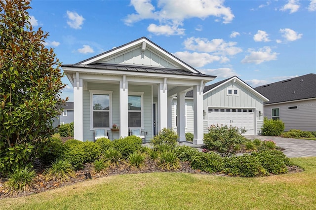 view of front facade featuring a garage, a front lawn, and a porch