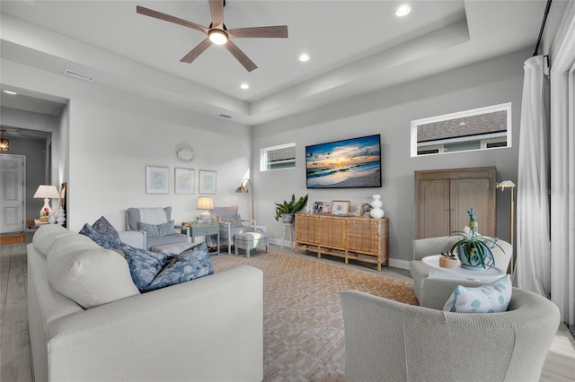 living room with visible vents, recessed lighting, baseboards, a raised ceiling, and ceiling fan