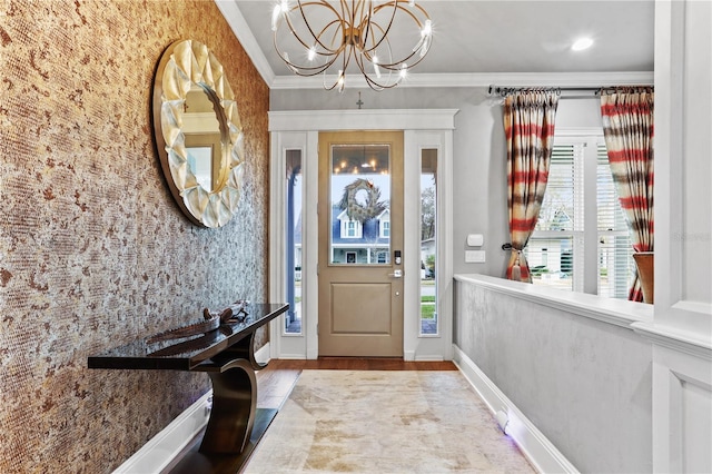 foyer featuring an inviting chandelier, ornamental molding, and light wood-type flooring