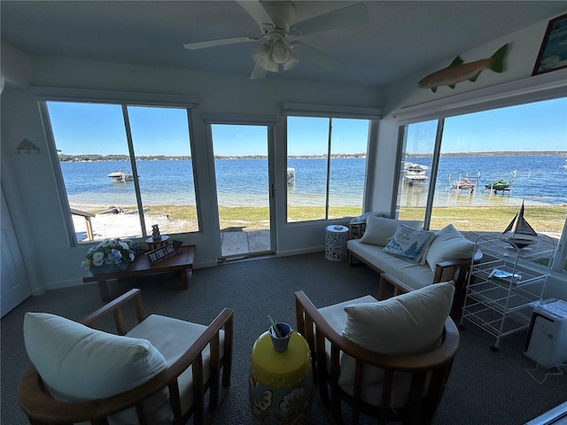 interior space featuring a view of the beach, ceiling fan, and a water view