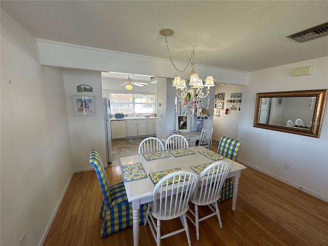 dining space featuring hardwood / wood-style floors and an inviting chandelier