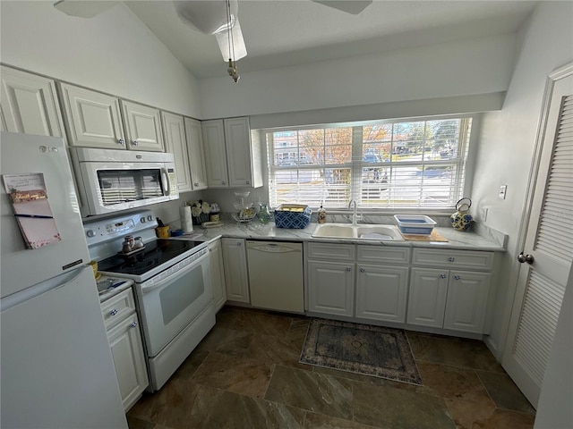 kitchen featuring white cabinetry, lofted ceiling, sink, and white appliances