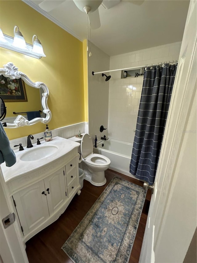 full bathroom featuring hardwood / wood-style floors, ornamental molding, vanity, toilet, and shower / bath combo