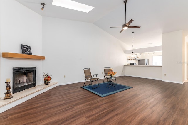 interior space featuring ceiling fan, high vaulted ceiling, dark hardwood / wood-style flooring, and a skylight