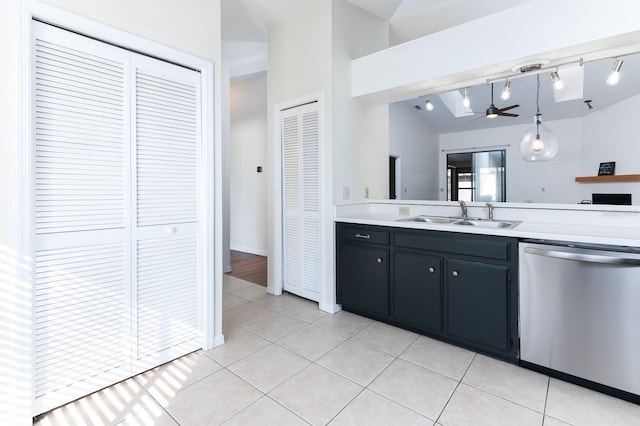 kitchen with light tile patterned flooring, vaulted ceiling, decorative light fixtures, sink, and stainless steel dishwasher