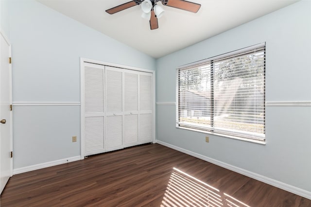 unfurnished bedroom featuring dark hardwood / wood-style flooring, vaulted ceiling, a closet, and ceiling fan