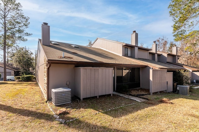 back of property with a lawn and central air condition unit