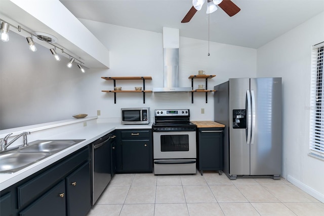 kitchen with light tile patterned flooring, appliances with stainless steel finishes, sink, and wall chimney range hood