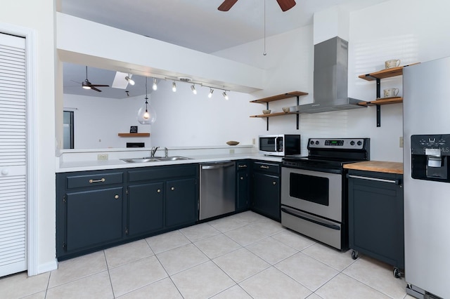 kitchen featuring sink, appliances with stainless steel finishes, hanging light fixtures, island exhaust hood, and light tile patterned flooring