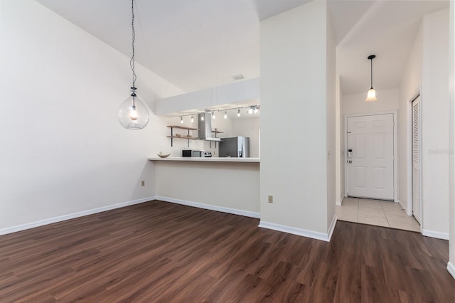 unfurnished living room featuring dark wood-type flooring and vaulted ceiling