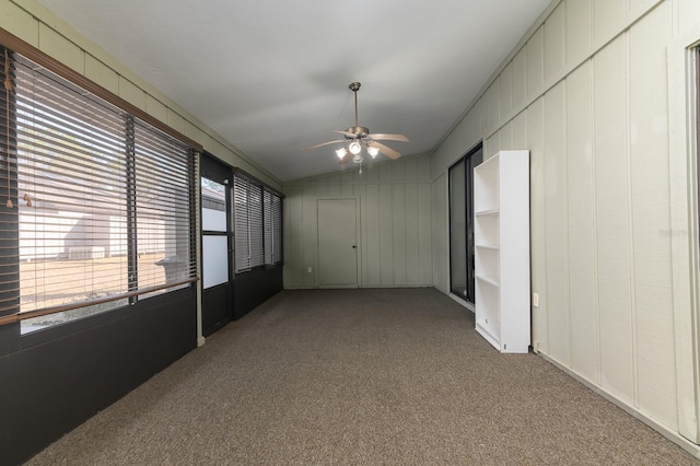 carpeted empty room featuring ceiling fan and lofted ceiling