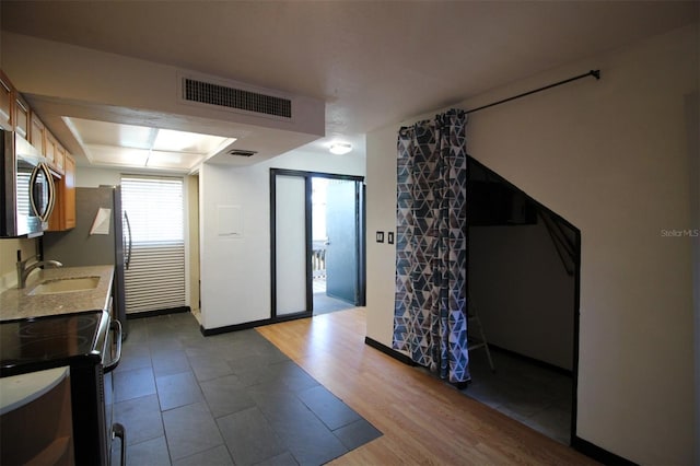 kitchen with sink, range with electric cooktop, and light hardwood / wood-style floors