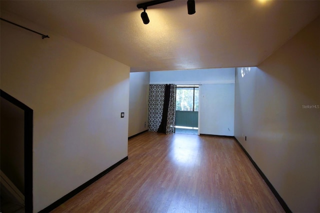 additional living space featuring hardwood / wood-style floors and a textured ceiling