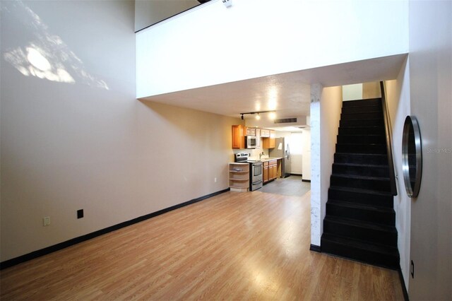 unfurnished living room featuring sink and light hardwood / wood-style flooring