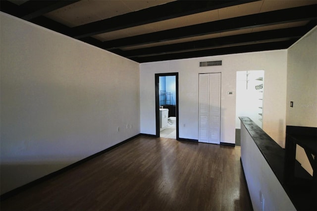 empty room with beamed ceiling and dark hardwood / wood-style flooring