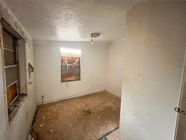 unfurnished room featuring a textured ceiling