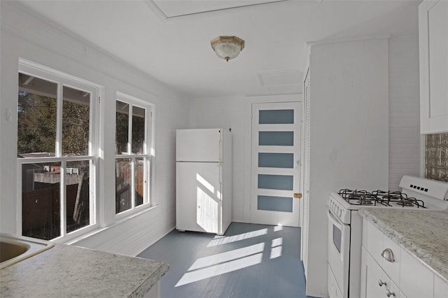 kitchen with white cabinetry and white appliances