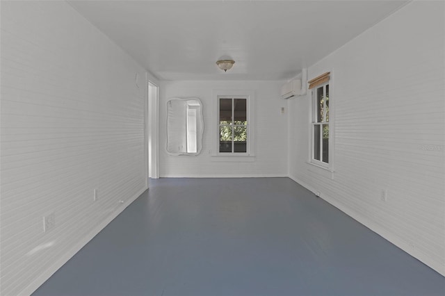 interior space featuring brick wall, concrete flooring, and a wall mounted AC