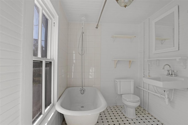 bathroom with a bathing tub, sink, a healthy amount of sunlight, and toilet