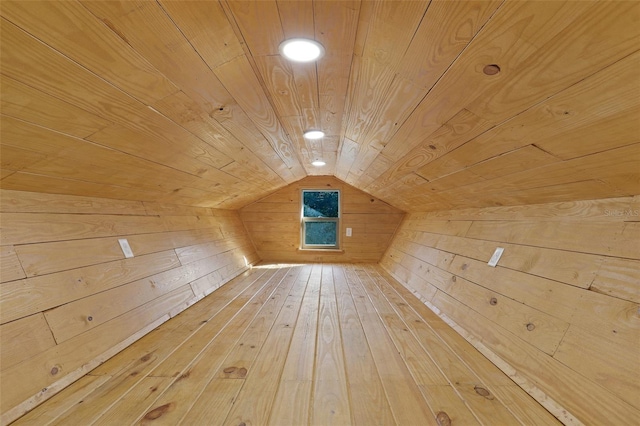 additional living space with hardwood / wood-style flooring, wooden walls, wooden ceiling, and vaulted ceiling