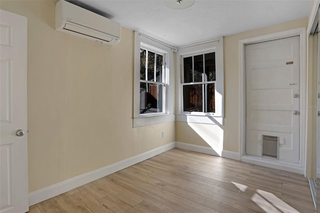 interior space featuring a wall mounted air conditioner and light hardwood / wood-style floors