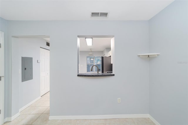 spare room featuring light tile patterned floors and electric panel