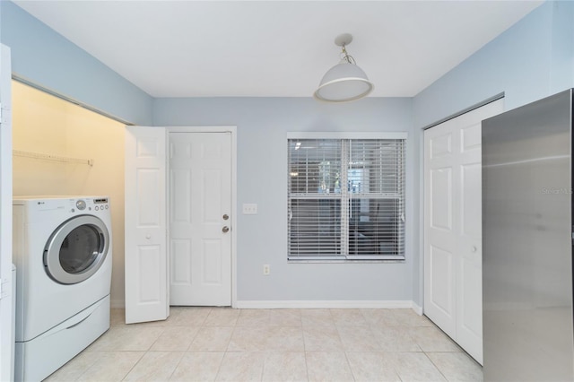 clothes washing area featuring light tile patterned flooring and washer / dryer