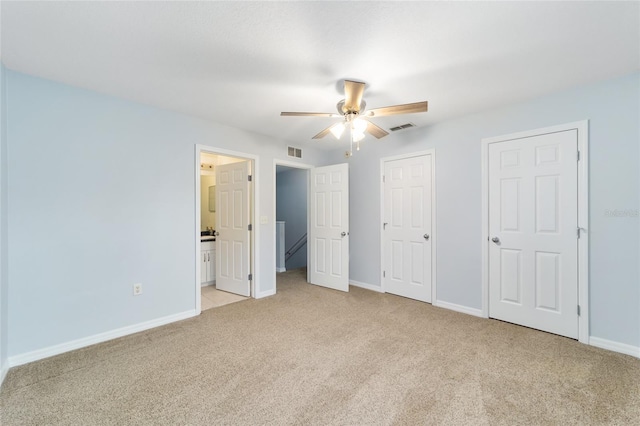 unfurnished bedroom featuring light carpet, connected bathroom, and ceiling fan