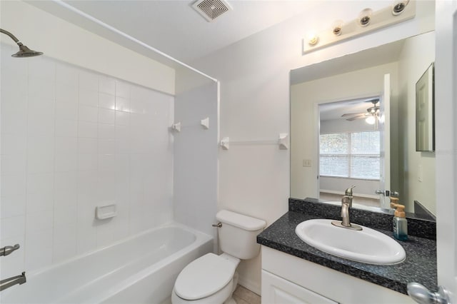 full bathroom featuring vanity, ceiling fan, toilet, and tiled shower / bath