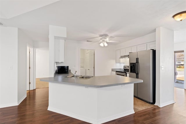 kitchen featuring dark wood-type flooring, sink, kitchen peninsula, stainless steel appliances, and white cabinets