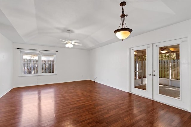 spare room featuring a tray ceiling, dark hardwood / wood-style floors, ceiling fan, and french doors