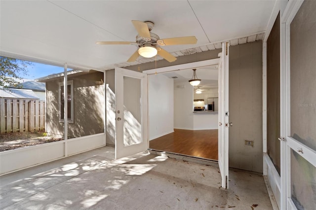 unfurnished sunroom featuring ceiling fan