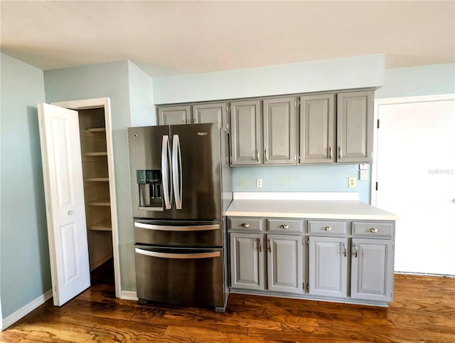 kitchen with dark wood-type flooring, stainless steel fridge, and gray cabinets