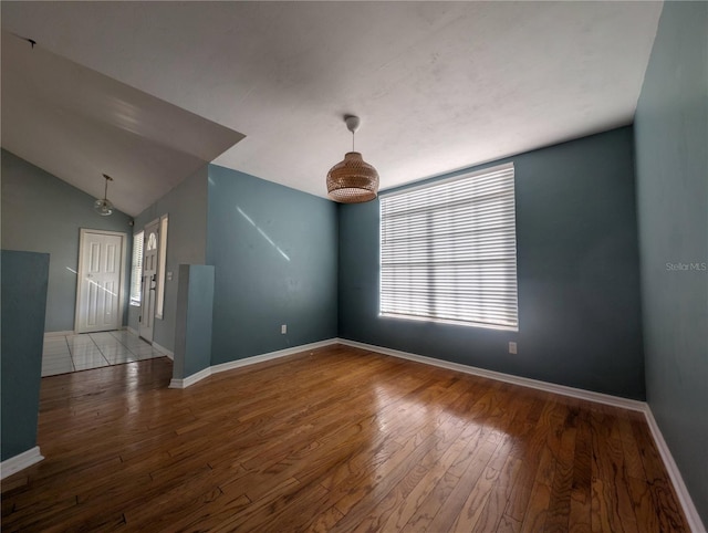 spare room with hardwood / wood-style flooring, vaulted ceiling, and a healthy amount of sunlight