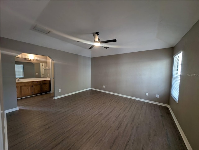 empty room with dark hardwood / wood-style floors and ceiling fan